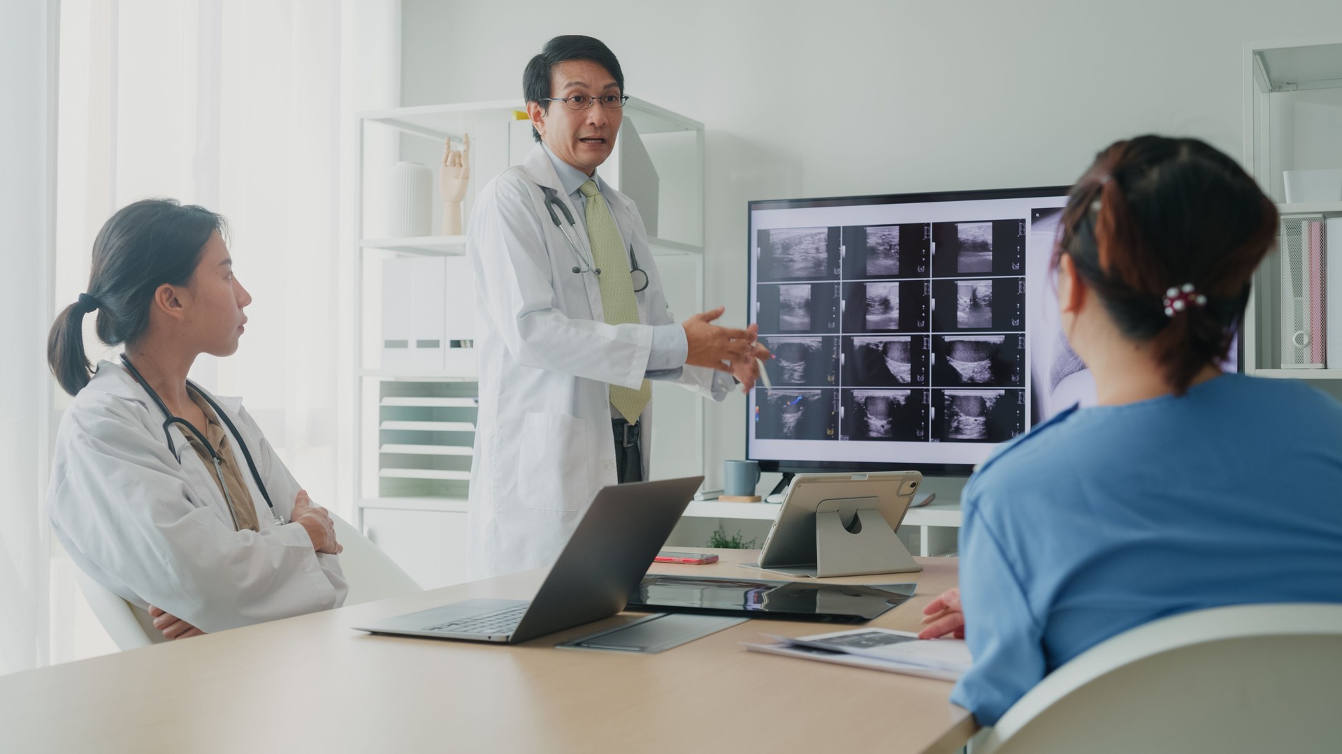 Medical team Asian male and female doctors medical checking x-ray image of patient on computer discussing result meeting in hospital. Medical health care.